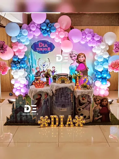 A magical 'Frozen' party for Dia's second birthday. The decor includes a beautiful balloon arch in shades of pink, purple, and blue, with all the favorite characters making an appearance.