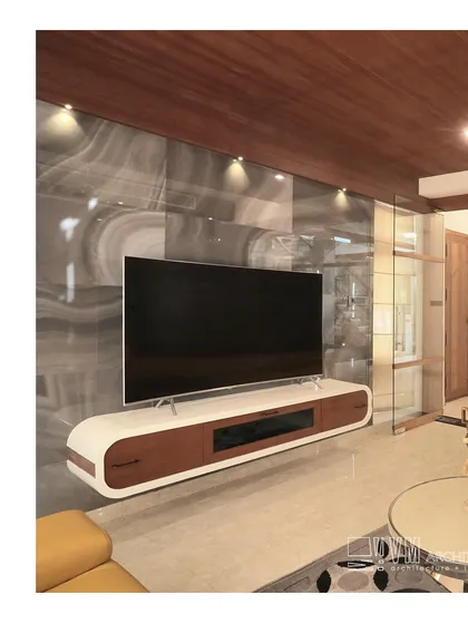 The media unit in Mannath House features a floating console and a dramatic marble-look wall, creating a sleek and modern entertainment zone.