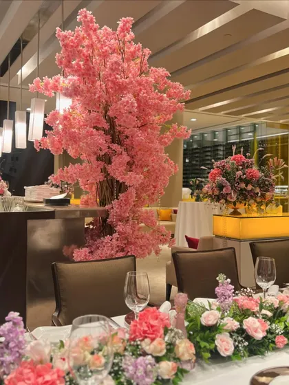 We transformed a restaurant space with beautiful pink floral arrangements, including a stunning cherry blossom tree centerpiece and lush table runners, creating a soft and romantic dining experience.