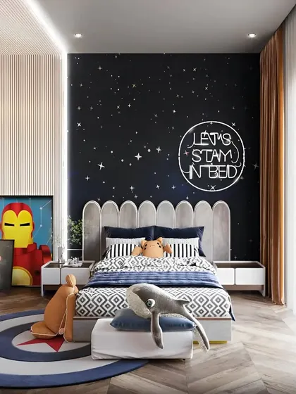 A superhero and space-themed bedroom for a little adventurer. The starry night accent wall with a neon sign, combined with Iron Man artwork, creates a room that sparks imagination.