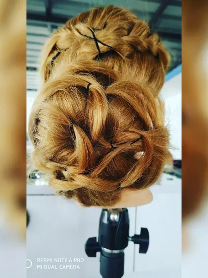 A look at a work-in-progress textured bun, showing the technique of pinning individual curls. This style creates a soft, romantic, and slightly messy look that is very popular for pre-wedding photoshoots.