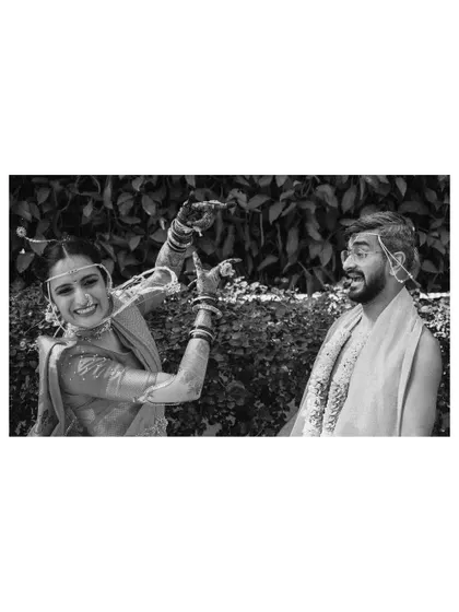 A playful black and white shot of the couple. The bride is making a funny face at the groom, showcasing a candid, unposed moment of joy.