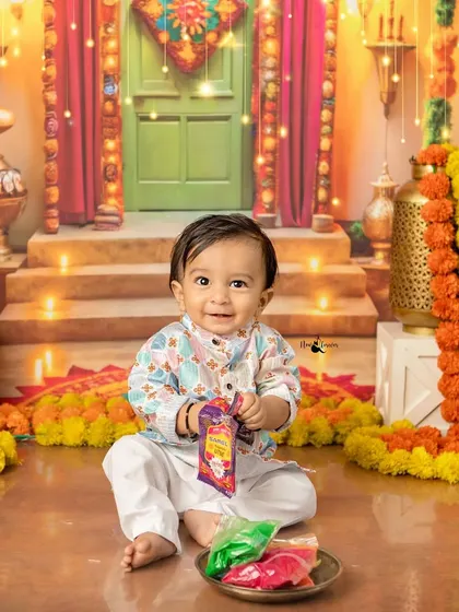 A bright smile for Diwali. This little one is enjoying our vibrant and festive Diwali setup, complete with diyas, marigolds, and colorful decorations.