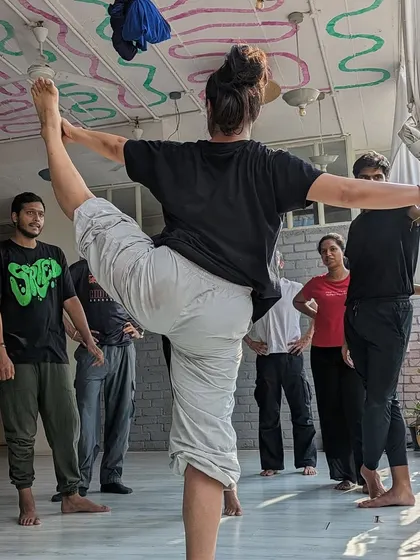 An instructor demonstrates a graceful and powerful pose, inspiring our beginner students with what's possible through practice.