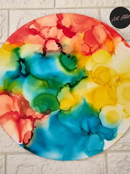 A vibrant, circular artwork made with alcohol inks, showcasing a rainbow of colors. This is an example of the large-scale pieces we create in my classes.