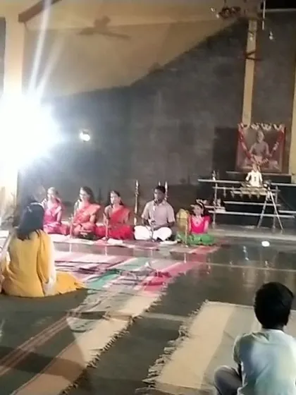 A glimpse from our Pournami celebrations, showing a music offering by students in our serene meditation hall. A young observer sits in the foreground, absorbed in the performance.