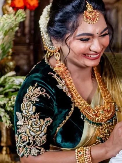 A close-up of our happy client in her deep green velvet blouse. The rich gold floral embroidery on the sleeve stands out beautifully, adding a touch of regal elegance to her festive look.