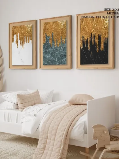 This set of three gold abstract prints is shown with natural broad floating frames in a child's room, demonstrating its versatility. The art adds a touch of magic and sophistication to the space.