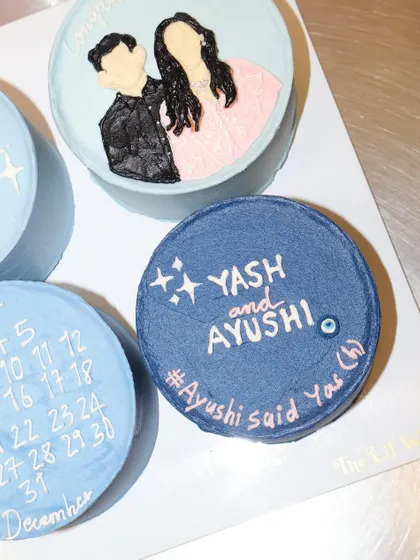 This bento cake from our engagement set features the couple's names and a custom hashtag. The deep blue color and sparkling star details make it a stylish and modern announcement.