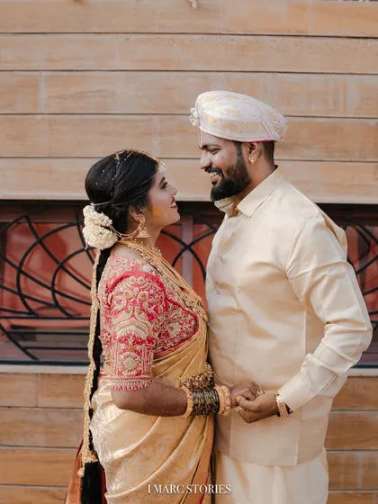 The happy couple sharing a look. The bride's custom blouse perfectly complements her groom's traditional attire.