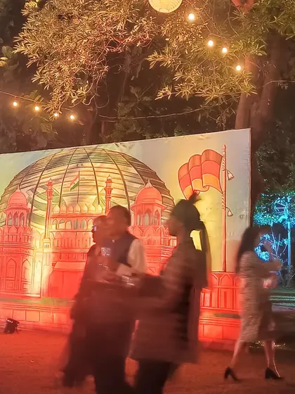 The completed Red Fort mural seen at night during the event, illuminated by festive lights. My backdrops are designed to be impactful in any lighting.