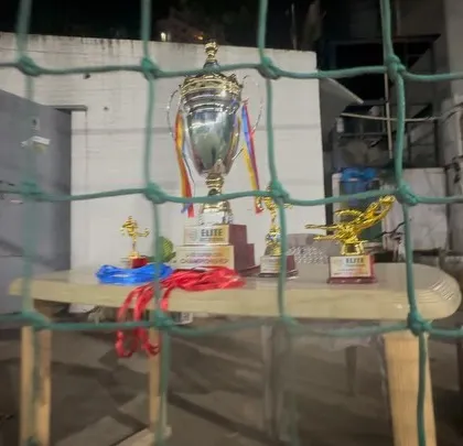 A view of the U13 Super Cup trophies through the net, with the tournament in full swing.