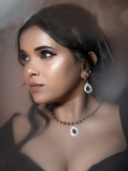 This portrait highlights the beautiful jewelry and the neckline of the dress. The warm lighting and soft focus create an intimate and glamorous mood, perfect for a beauty or accessory shoot.