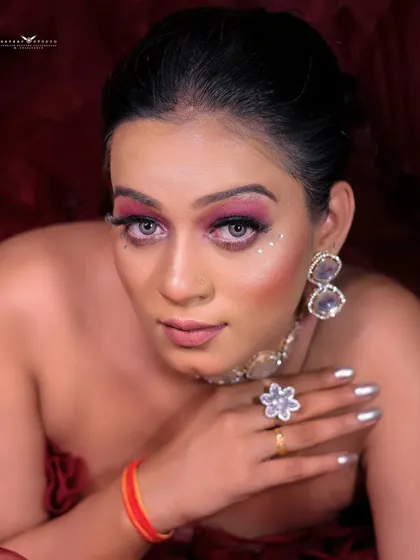 A close-up portrait capturing the model's direct gaze and the striking details of her makeup.