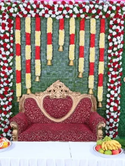 A closer look at the traditional Seemantha backdrop, showing the detail in the floral garlands and the woven coconut leaf mat.