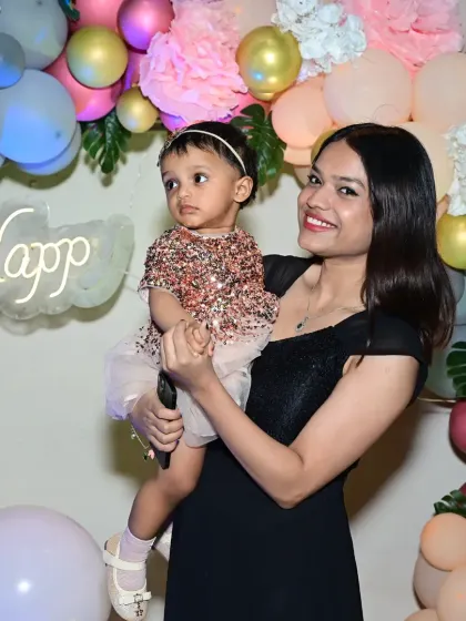 A mother and her one-year-old daughter posing for a photo. I design my party setups to be the perfect backdrop for your family portraits.