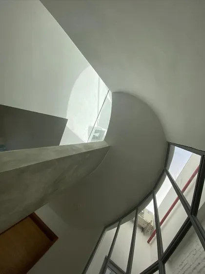 Light is a building material. This sculpted, non-rectilinear skylight is designed to do more than just illuminate; it channels sunlight, creating dynamic patterns of light and shadow that change throughout the day, turning the space into a living sundial.