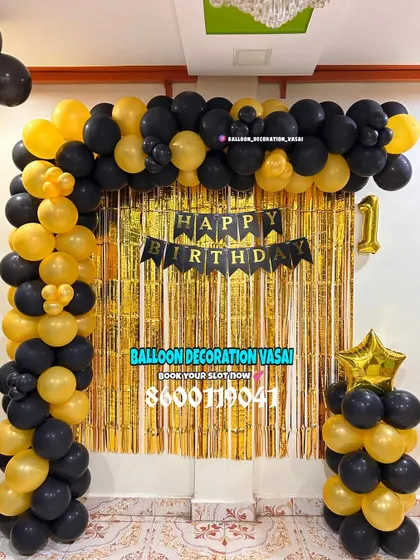 A classic black and gold balloon arch against a gold shimmer curtain. This is a timeless choice for any birthday party.