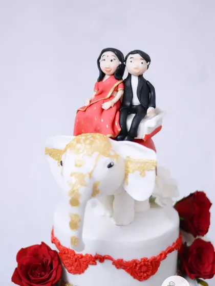 The complete view of the couple figurine, showcasing the detail in their traditional attire, all handcrafted from edible materials.