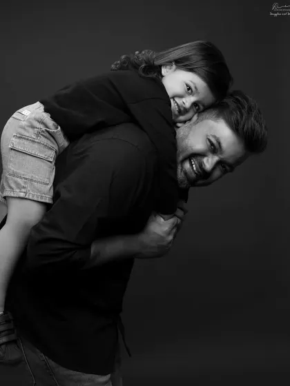 A piggyback ride from dad is always a good idea. The genuine smiles in this black and white portrait are what it's all about.
