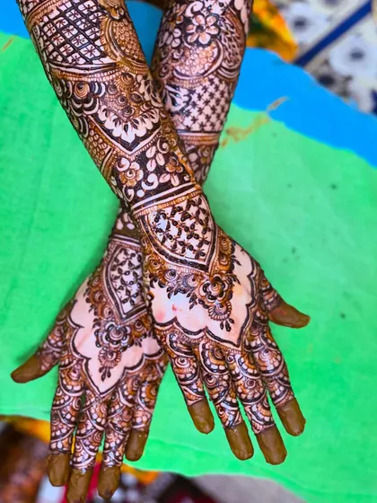 A stunning bridal henna design with intricate patterns and a beautiful scalloped border.