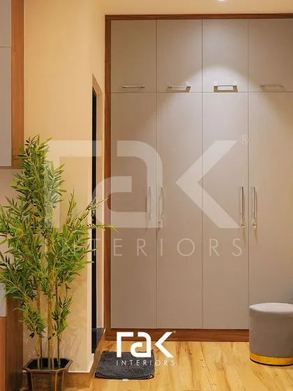 This entryway storage solution combines a full-height wardrobe, a bench with drawers, and a beautifully lit vanity corner. The mix of grey and wood finishes creates a modern and welcoming first impression.