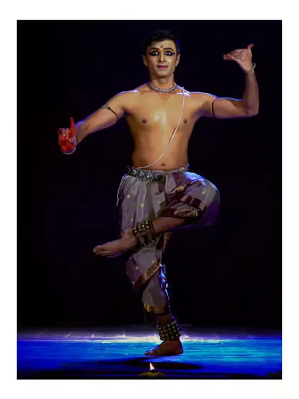 A dynamic pose from a solo performance, with one leg raised in a graceful line. This showcases the balance and control required in Bharatanatyam.