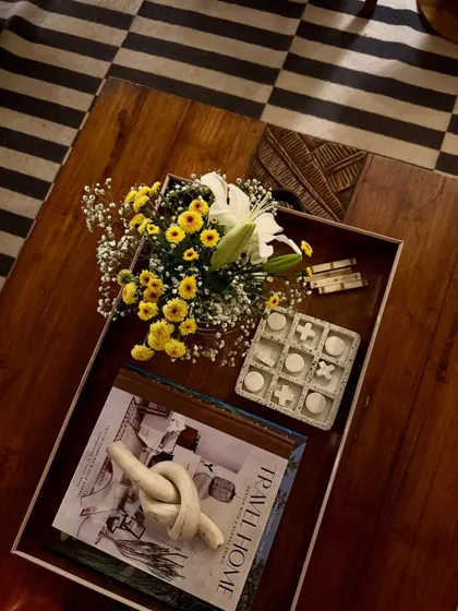 Styling a coffee table is an art. Here, a tray holds a mix of fresh flowers, books, and decorative objects, creating a beautiful and personal vignette in my own home.