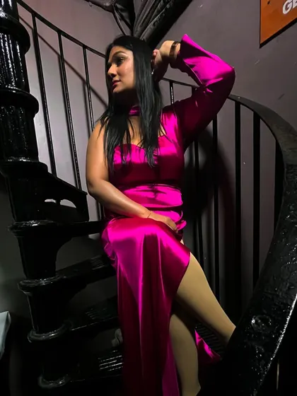 A striking pose in a satin pink dress. My style is confident and bold, just like my hosting.