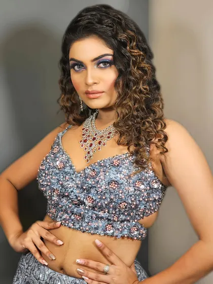 A powerful and confident pose showcasing a bold blue eye makeup look. This is for the woman who isn't afraid to stand out and make a statement.
