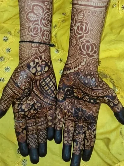 A dense design with a focus on rose motifs, covering the hands and wrists.