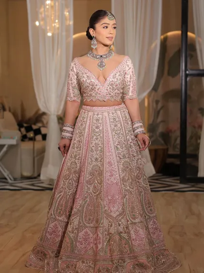 A full-length portrait of the bride in her modern pink lehenga. The confidence she exudes is what makes the outfit truly shine.