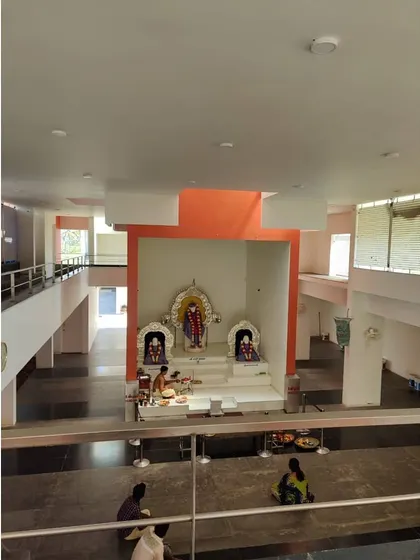 A view from the upper level of the Sai Temple, looking down into the main prayer hall. The design includes multi-functional spaces for community activities like music, dance, and events.