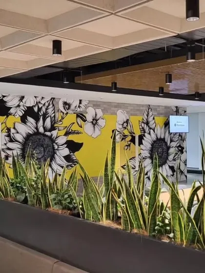 This view shows the sunflower mural behind a row of planters, creating a beautiful interplay between real and painted nature.