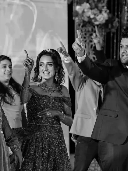 A candid black and white shot of the Sangeet night, capturing the energy of the dance floor as the couple and guests celebrate together.