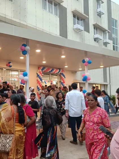The entrance of the Home for the Aged, bustling with community members during its opening ceremony. The covered entryway provides a welcoming and accessible transition into the building for residents and visitors.