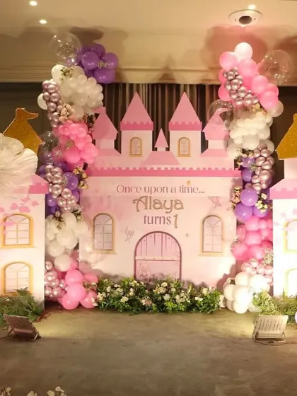 A princess castle stage setup with towers and a balloon garland. This is a classic theme that we love to create for little princesses.