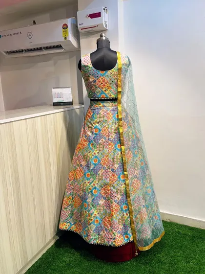 This multi-color printed lehenga is a fantastic option for a Mehendi function. The vibrant patchwork design and mirror-work blouse are festive and photogenic.