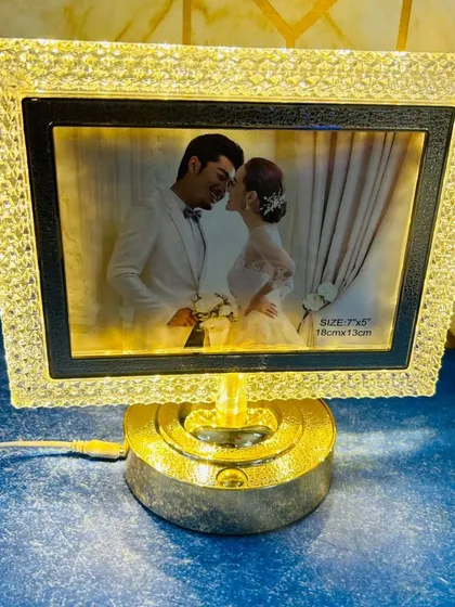 A rotating LED photo frame with a crystal-like border and a golden base. It lights up your photo while slowly turning.