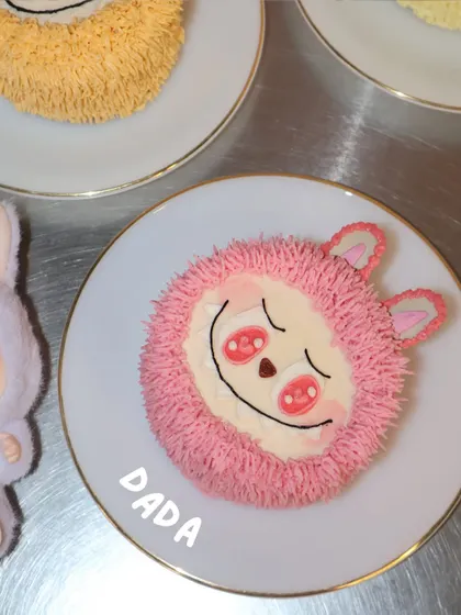 A close-up of our pink "Dada" Labubu cake, showing the intricate piping work that creates the character's signature fluffy look. It's a perfect edible version of the popular collectible toy.