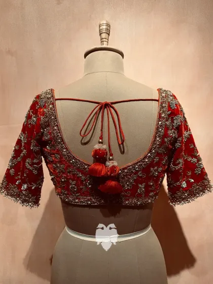 Jahnavi’s red velvet blouse, a perfect pre-wedding statement with detailed gold zardosi work and flowing creeper patterns.