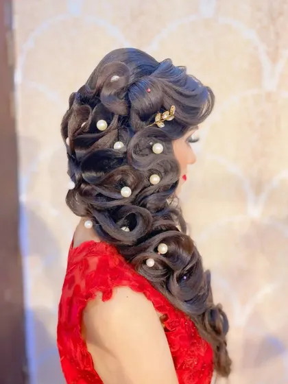 A perfect example of a glamorous reception hairstyle you will master. This look involves creating soft, cascading curls and expertly placing pearl accessories for a timeless and elegant finish.