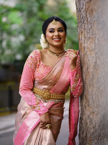 A full-length shot showing the elegant posture and drape of the saree. The golden belt cinches the waist and adds another layer of traditional detail.
