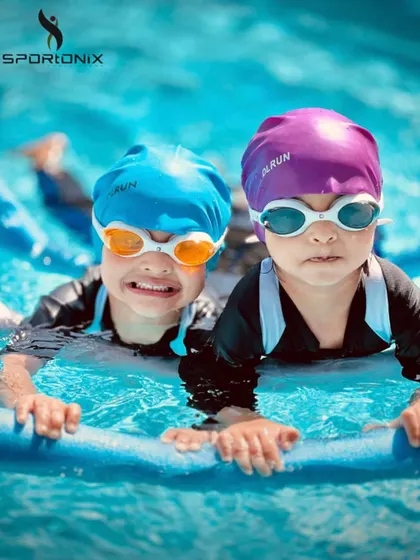Two little swimmers learning together. Using a flotation noodle, they build leg strength and confidence side-by-side in our toddler aquatics class.