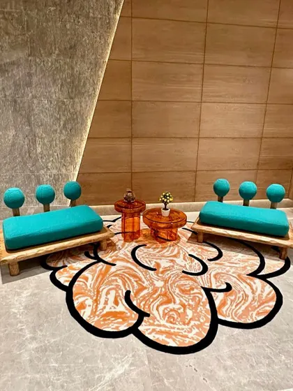 A pair of our playful benches with teal upholstery and spherical backrests, arranged on a custom rug. This setup shows how we create joyful and imaginative spaces.