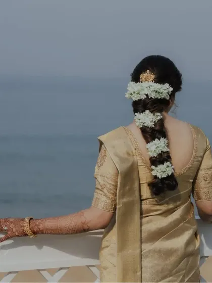 The back view of the bride's look, showcasing her beautiful hairstyle and the elegant fall of the saree pallu.