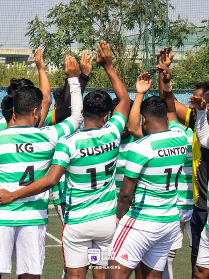 Players in green and white striped jerseys raise their hands in a team huddle, ready to take on their opponents. This is where strategies are made and spirits are lifted.