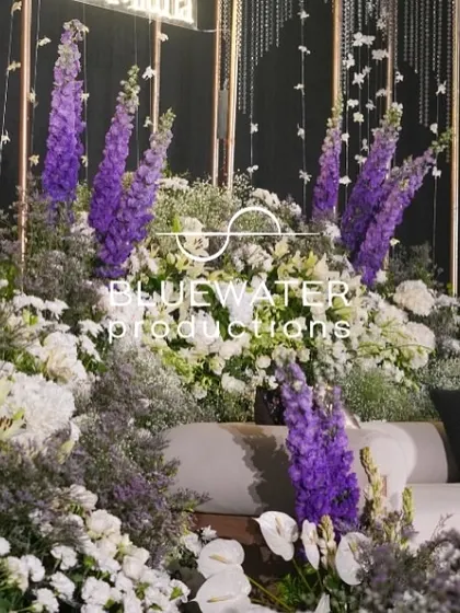 A close-up of the florals on the Sangeet photo stage, with purple delphiniums adding a pop of color to the white arrangements.