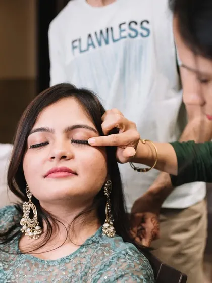 A final touch up. Even during the relaxed mehendi ceremony, everyone wants the bride to look her best.
