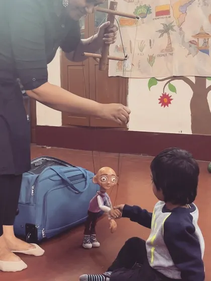 This is the magic spark. A young boy reaches out to shake hands with our 'Popo' thatha puppet, making a new friend. These are the beautiful, unscripted moments we cherish at every show.